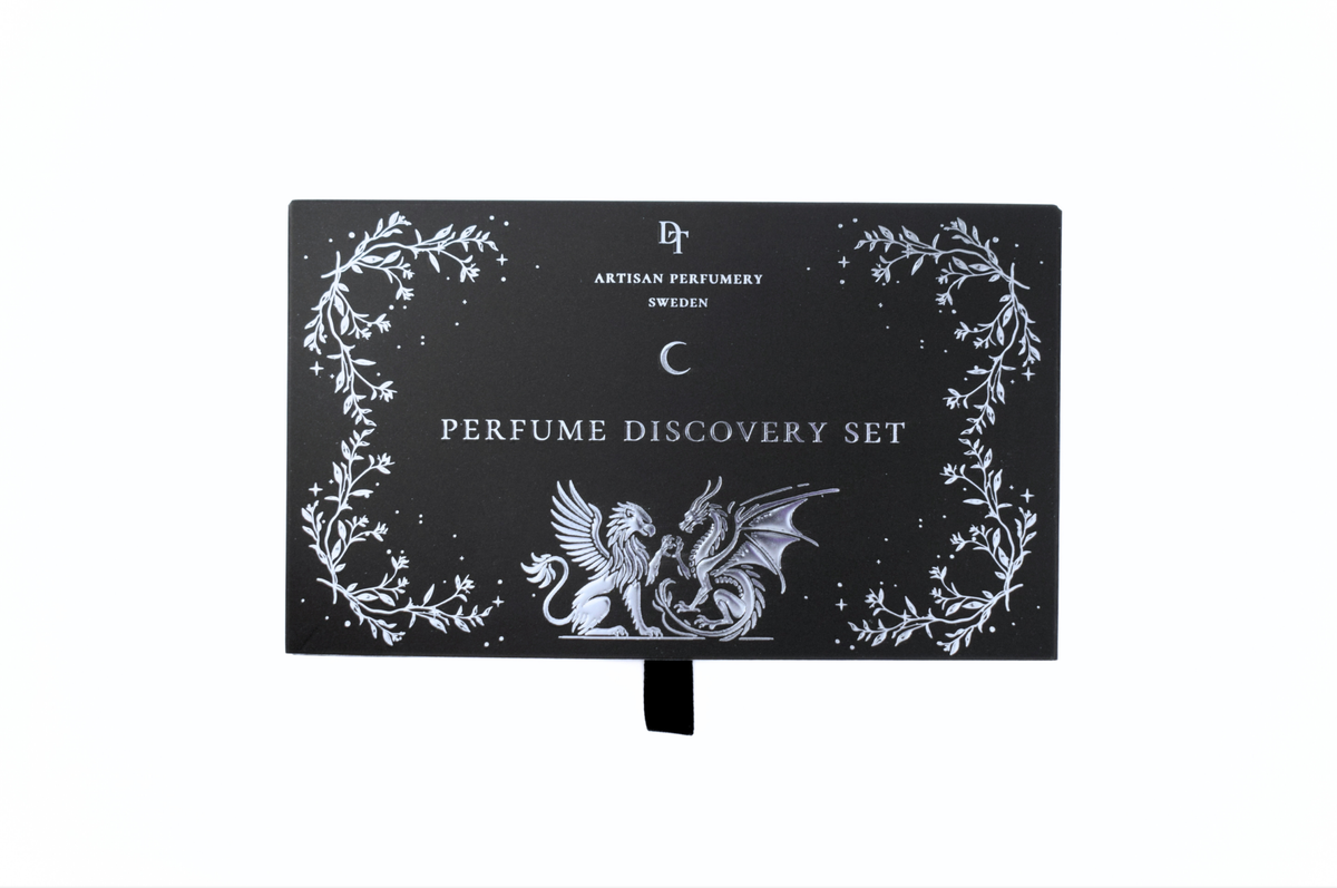 Discovery Set black perfume sample gift box with white botanical border, gothic dragon artwork, and pull ribbon