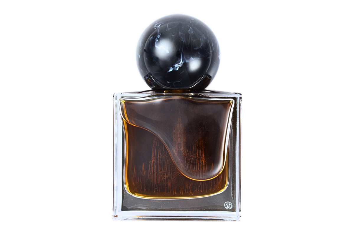 Gothika parfum in a clear square glass bottle with dark amber liquid, cathedral illustration, and black spherical cap