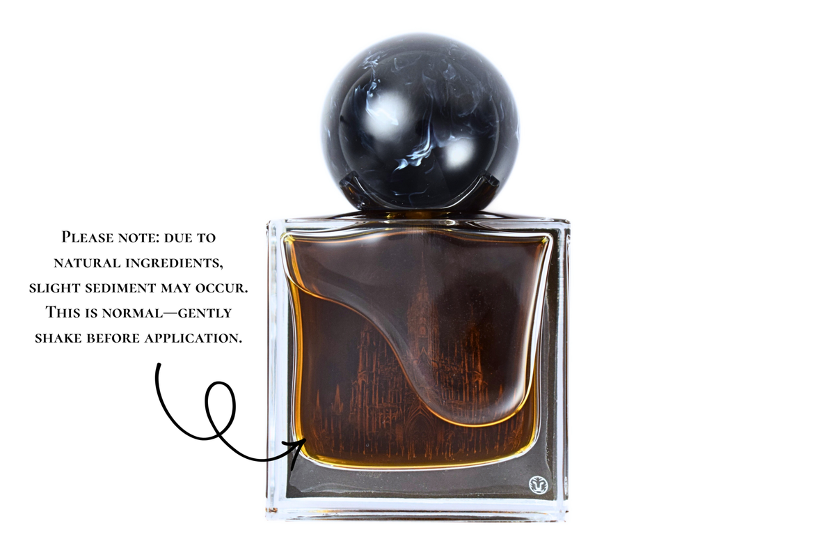 Gothika parfum bottle with dark amber liquid, clear glass, black spherical cap, and gothic cathedral design