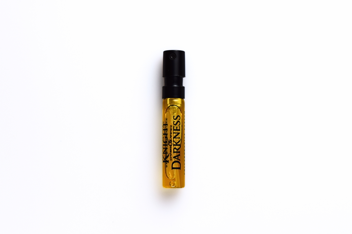 Parfum sample vial for Knight of Darkness with amber liquid, clear glass, black spray cap, and bold printed label