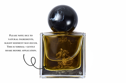 MACABRE parfum bottle with amber liquid, clear glass, black spherical cap, and ornate gold figure detail