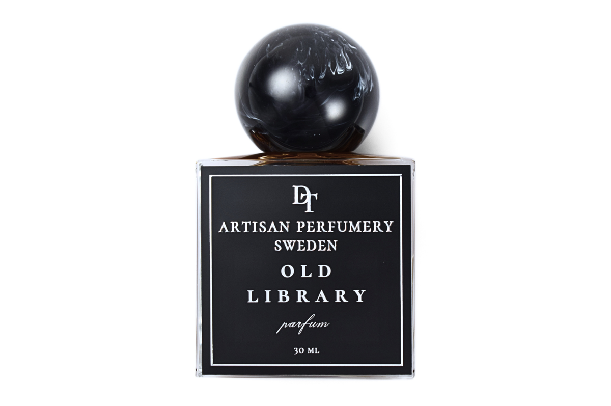 Old Library parfum bottle with black label, clear glass, dark liquid, and glossy black spherical cap