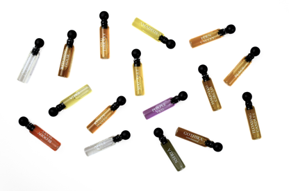 Quadro Set of assorted perfume sample vials in amber, yellow, purple, green, red, and clear glass with black caps