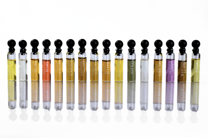 Quadro Set of unisex parfum sample vials with black caps, clear glass bottles, and assorted coloured fragrances